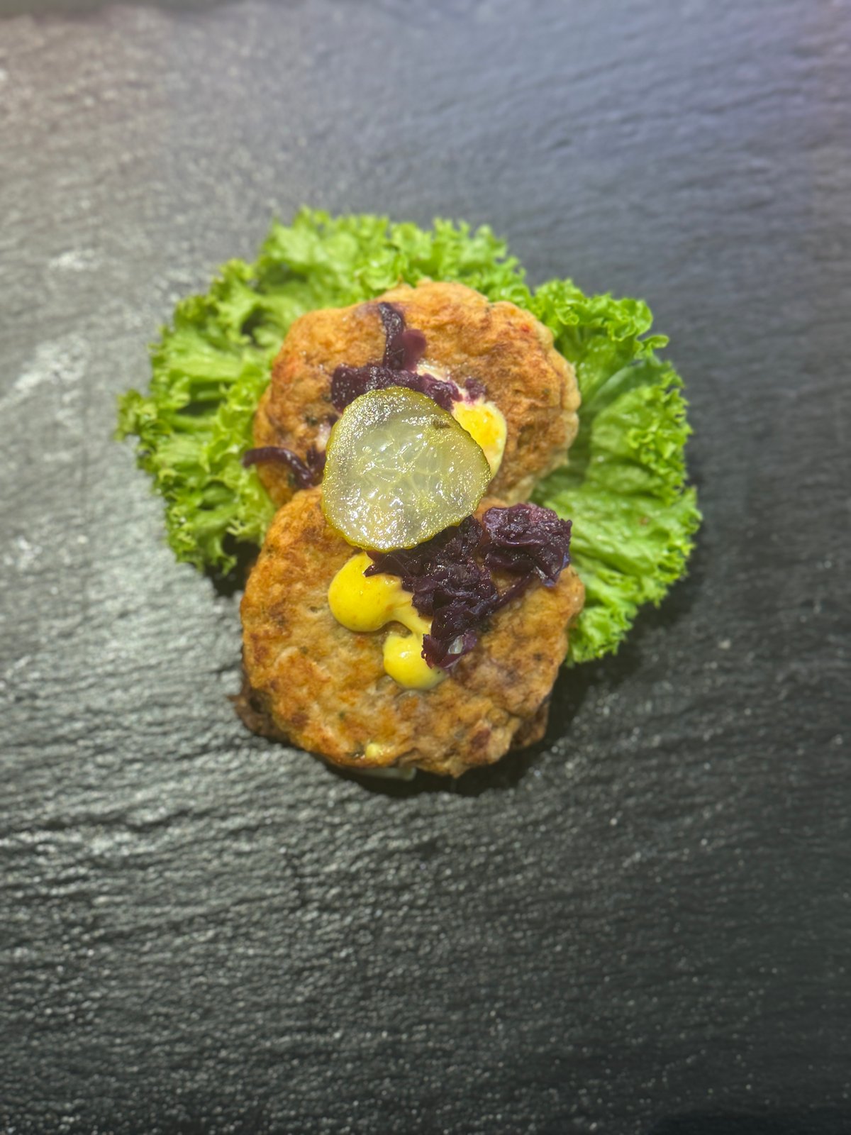 Frikadelle med remoulade, rødkål og syltede agurker.