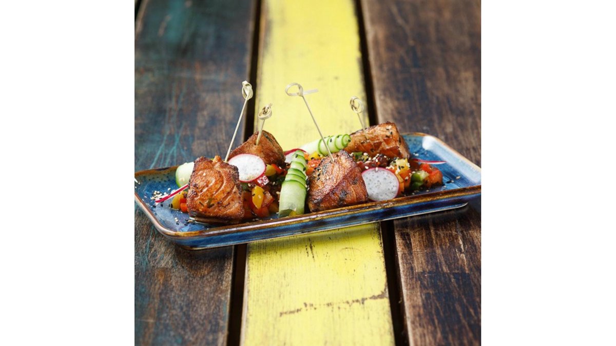 Marinated salmon skewers on a bed of bell peppers salsa