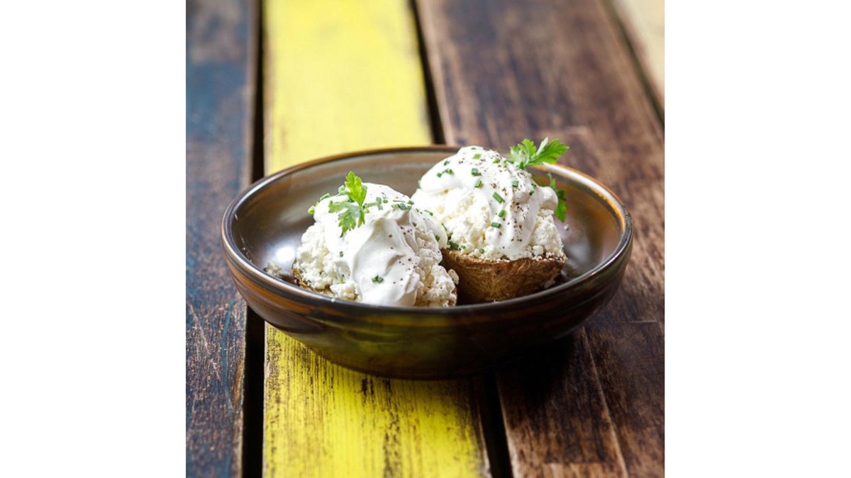 Whole baked potato with traditional sheep cheese and sour cream