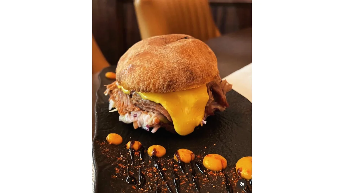 Burger cu fasii de porc gatite lent and sos cheddar