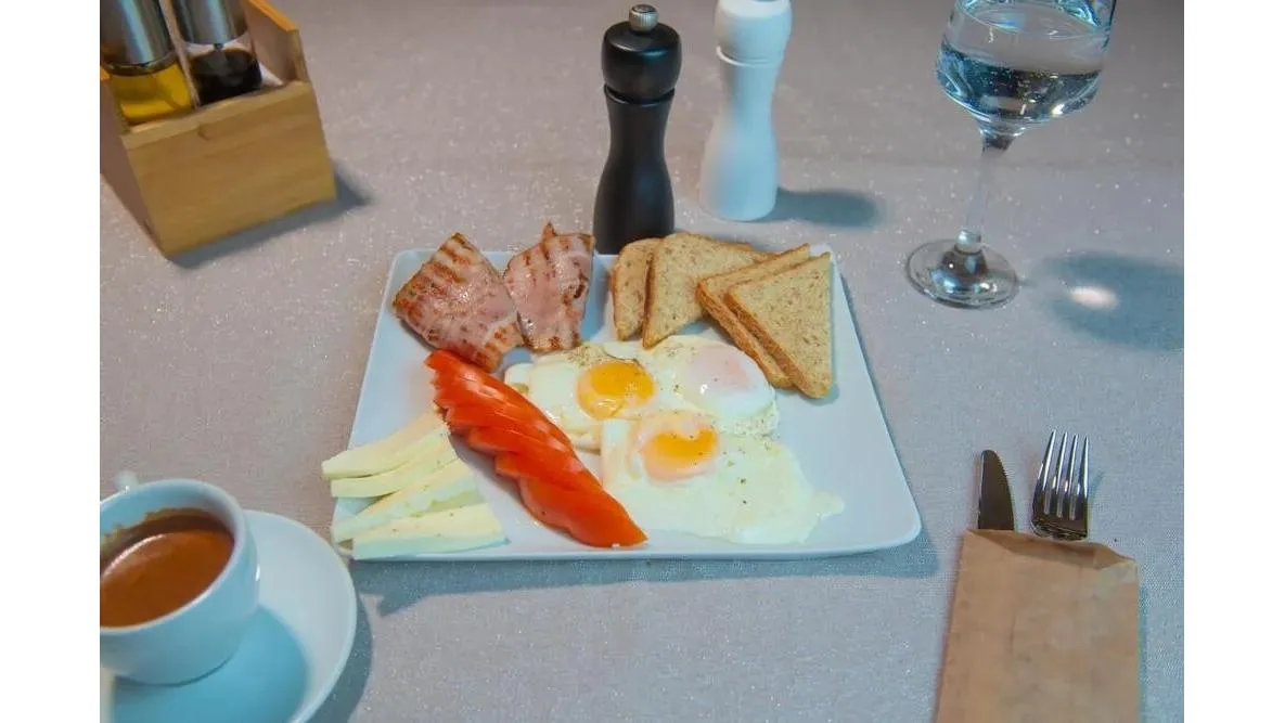 Ouă ochiuri cu brânză, roșii și bacon prăjit