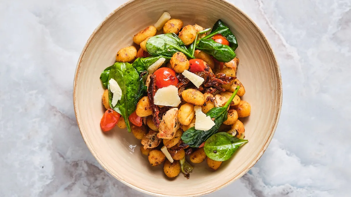 Pirított gnocchi zöldségekkel and fűszeres csirkemell kockákkal