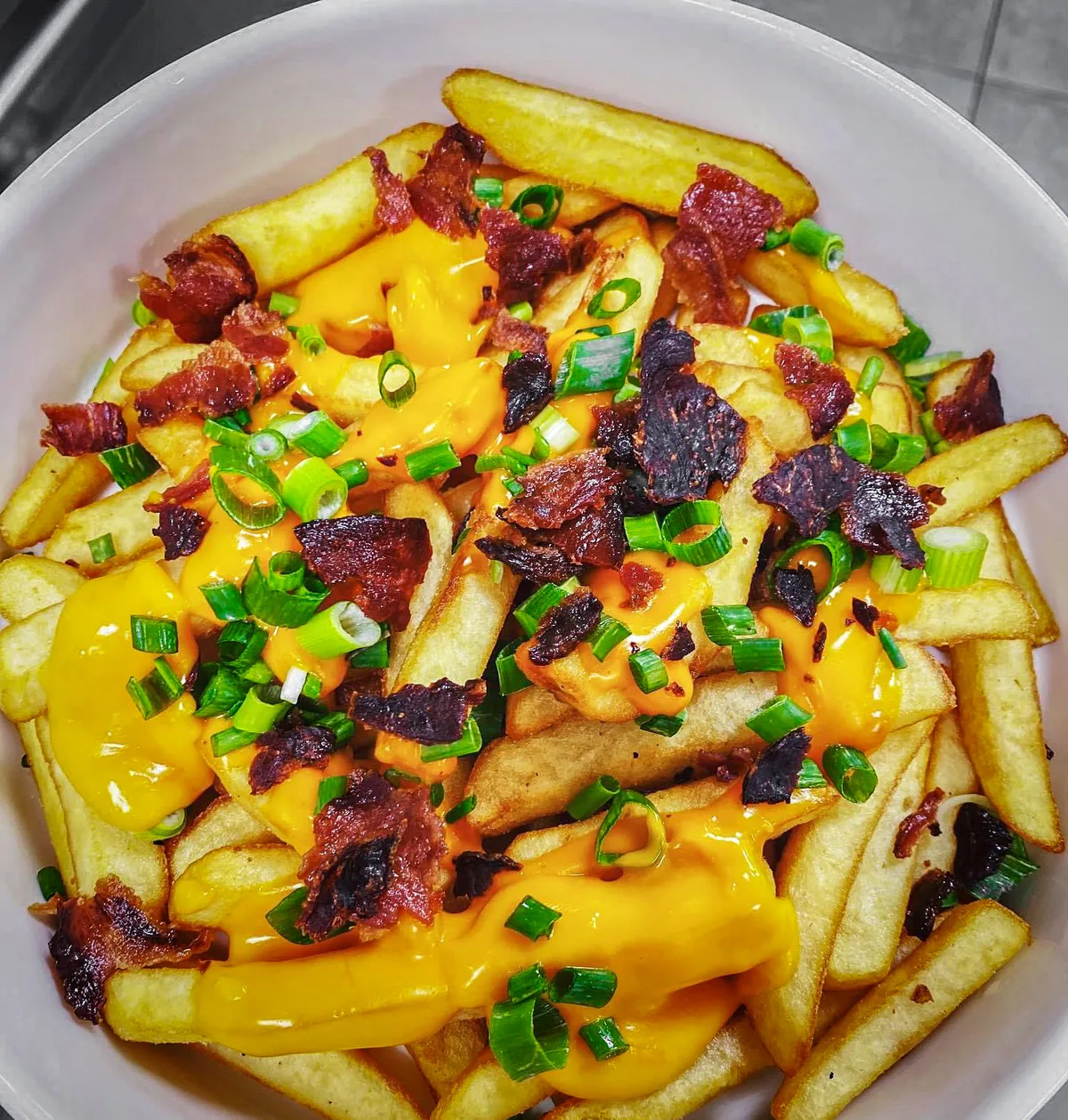 Serowe fryty z chrupiącym bekonem, prażoną cebulką, parmezanem i szczypiorkiem