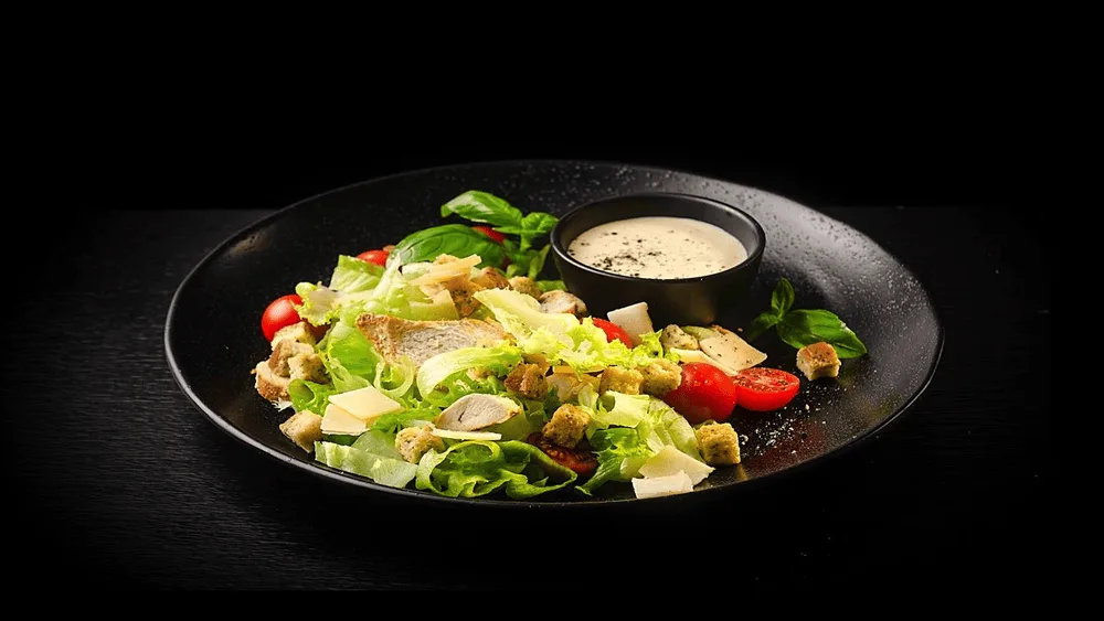 Caesar salad with chicken, cherry tomatoes, Parmesan, Caesar dressing, and crout