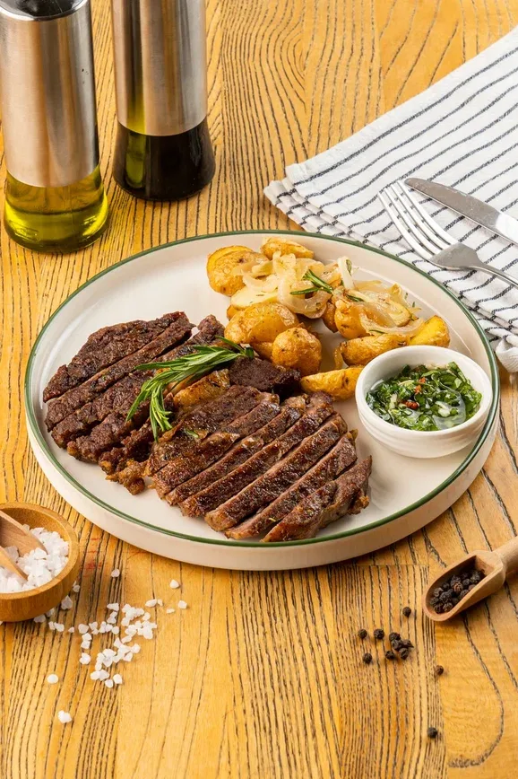 New York steak with potatoes and chimichurri sauce
