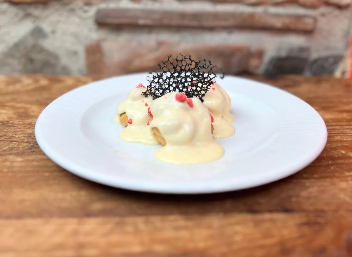 Pisztáciás profiterol fehércsokoládé mártásban, liofilizált málnával