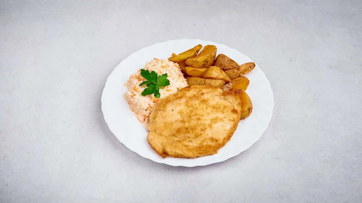Kotlet schabowy panierowany z ziemniakami opiekanymi w ziołach i surówką dnia
